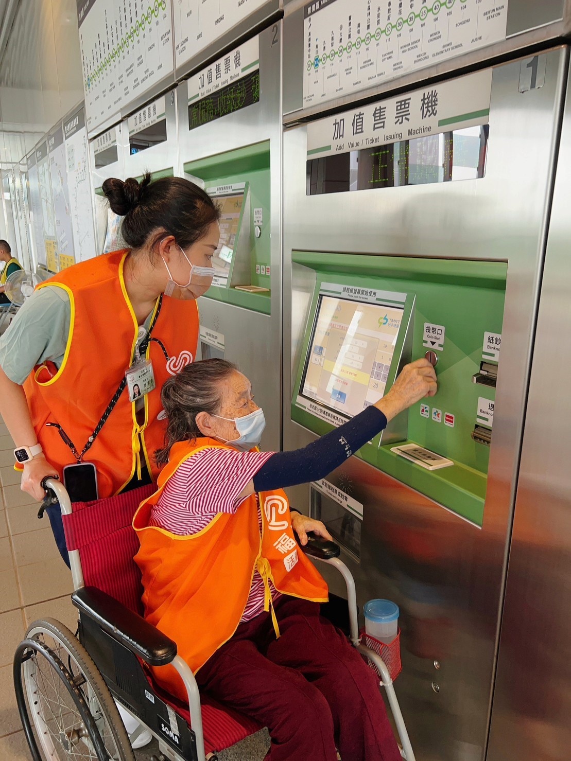 圖為長輩體驗使用投幣式機器，購票台中捷運車票。