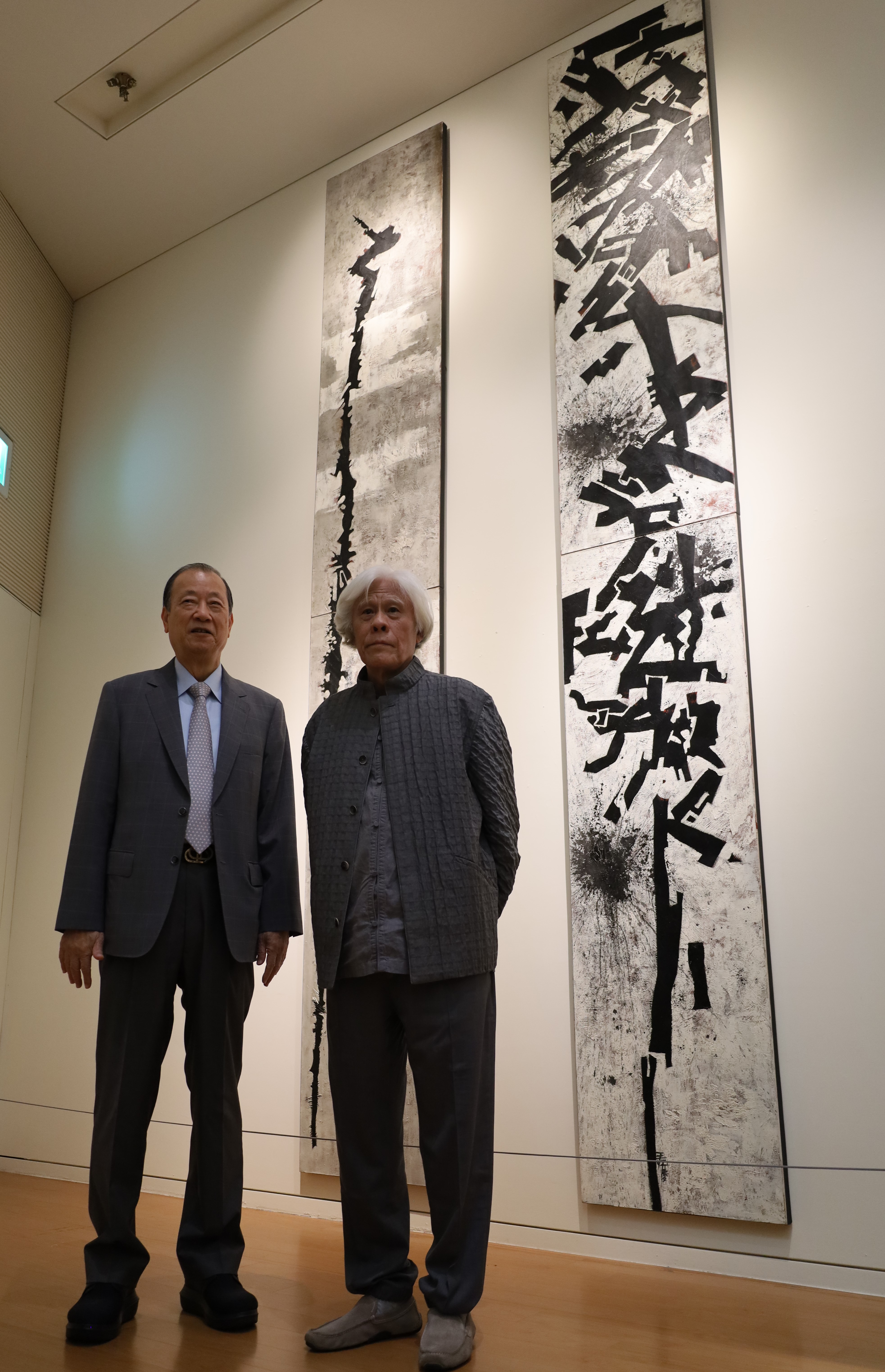 圖為王懷慶大師(右)、亞大創辦人蔡長海，在王懷慶大師的作品《鶴頭杖》、《連環棍》前合影。