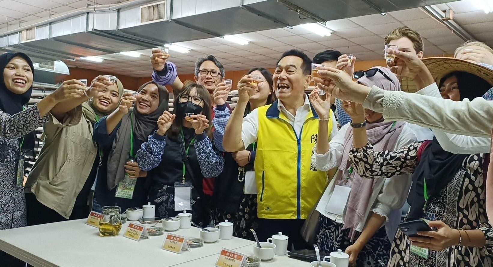 圖為南投竹山鎮長陳東睦(前排右3)，和亞大國際生一起飲用自採、自製的高山茶。