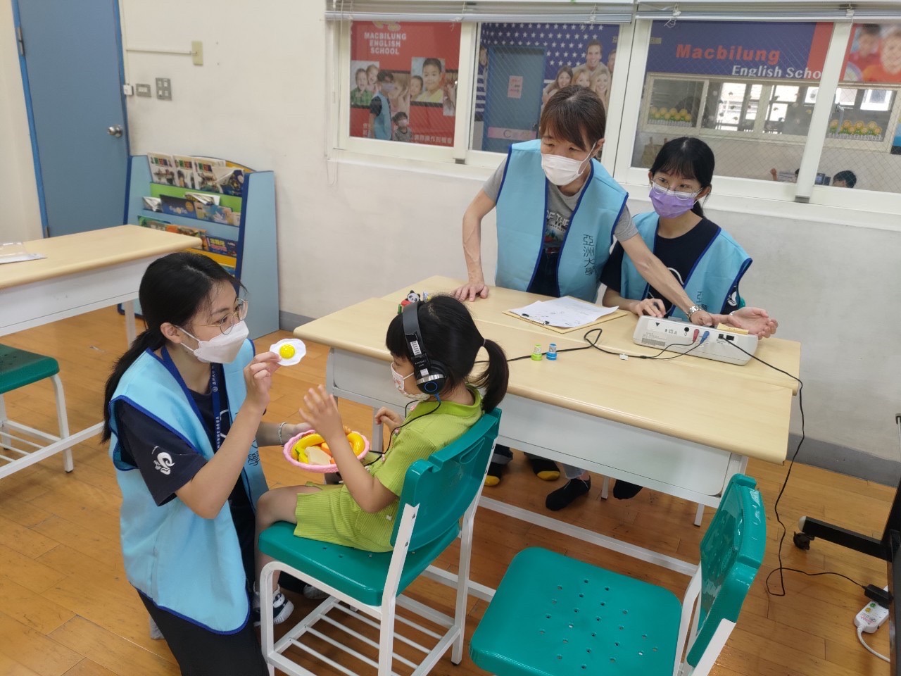 圖為亞大聽語系同學，到幼兒園以遊戲方式，為兒童進行聽力篩檢實習，強化實務專業能力。