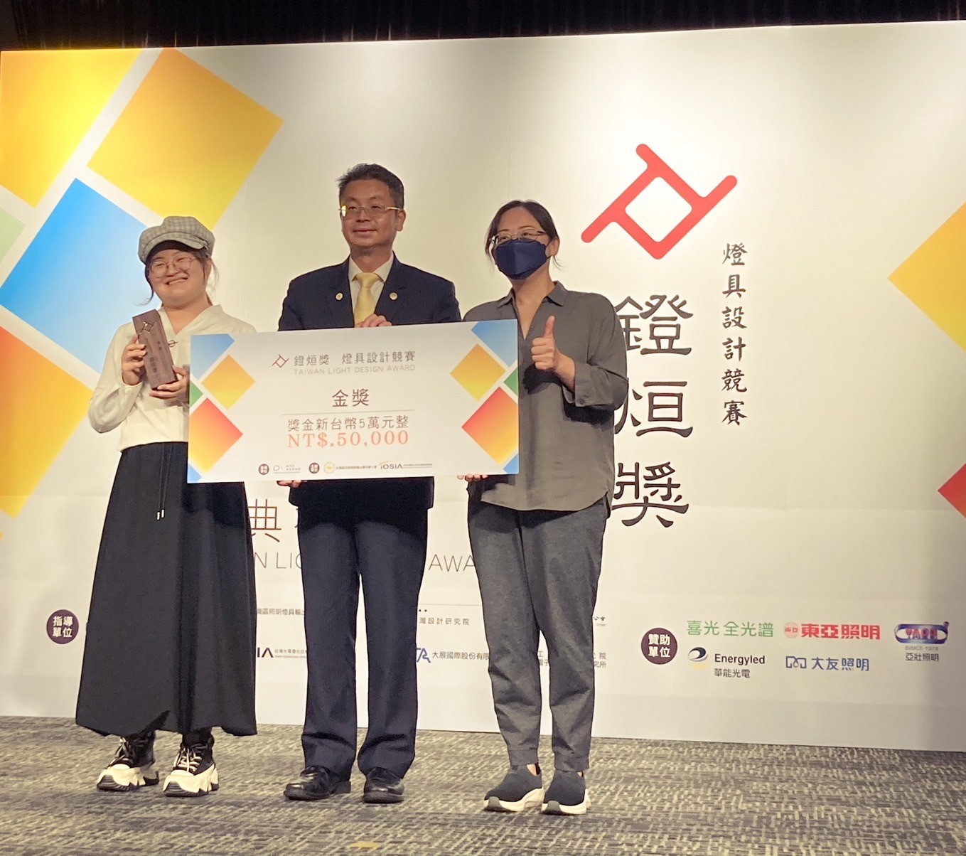 圖為亞大商設系同學作品《光竹舞》，獲「2024燈烜獎」金獎，由指導老師柯雅娟(右)、劉千瑜同學(左)代表領獎。