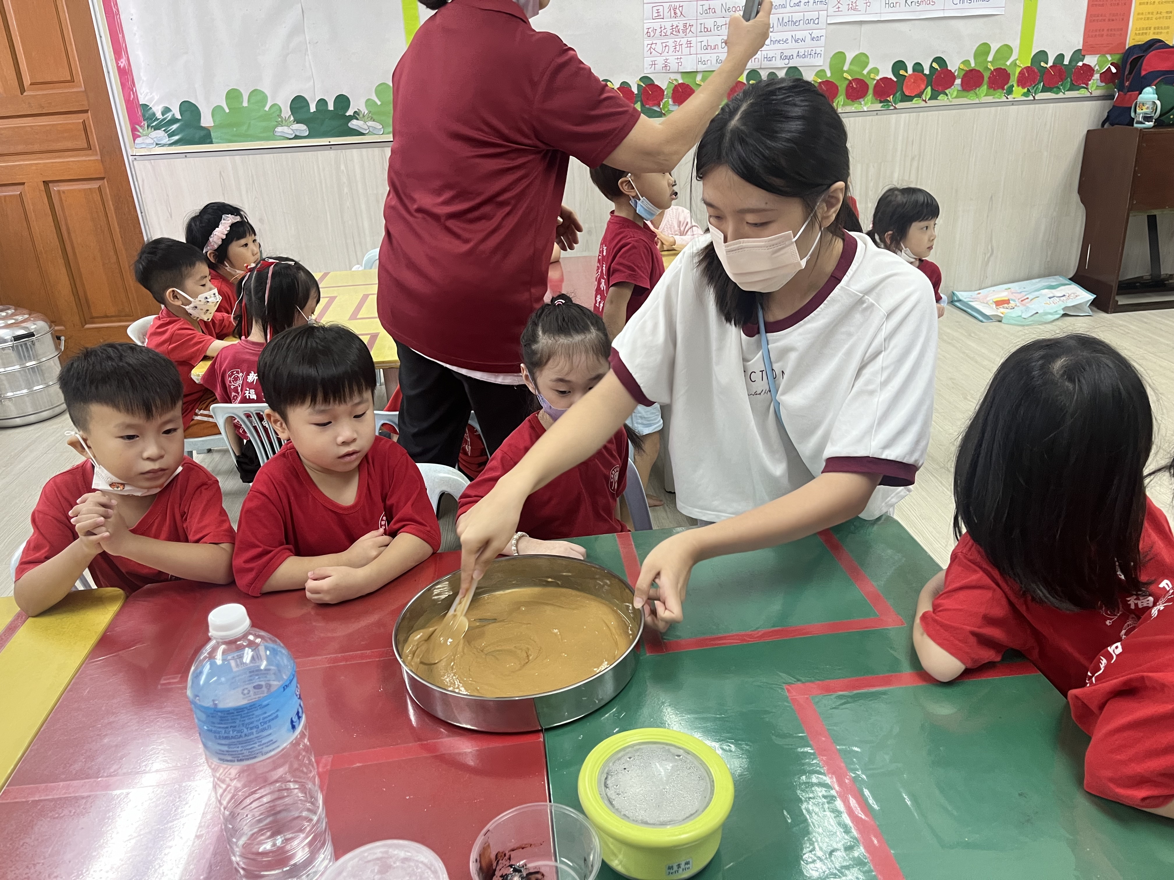 圖為亞大幼教系簡子寧同學，在馬來西亞實習時帶領幼兒製作黑糖糕。