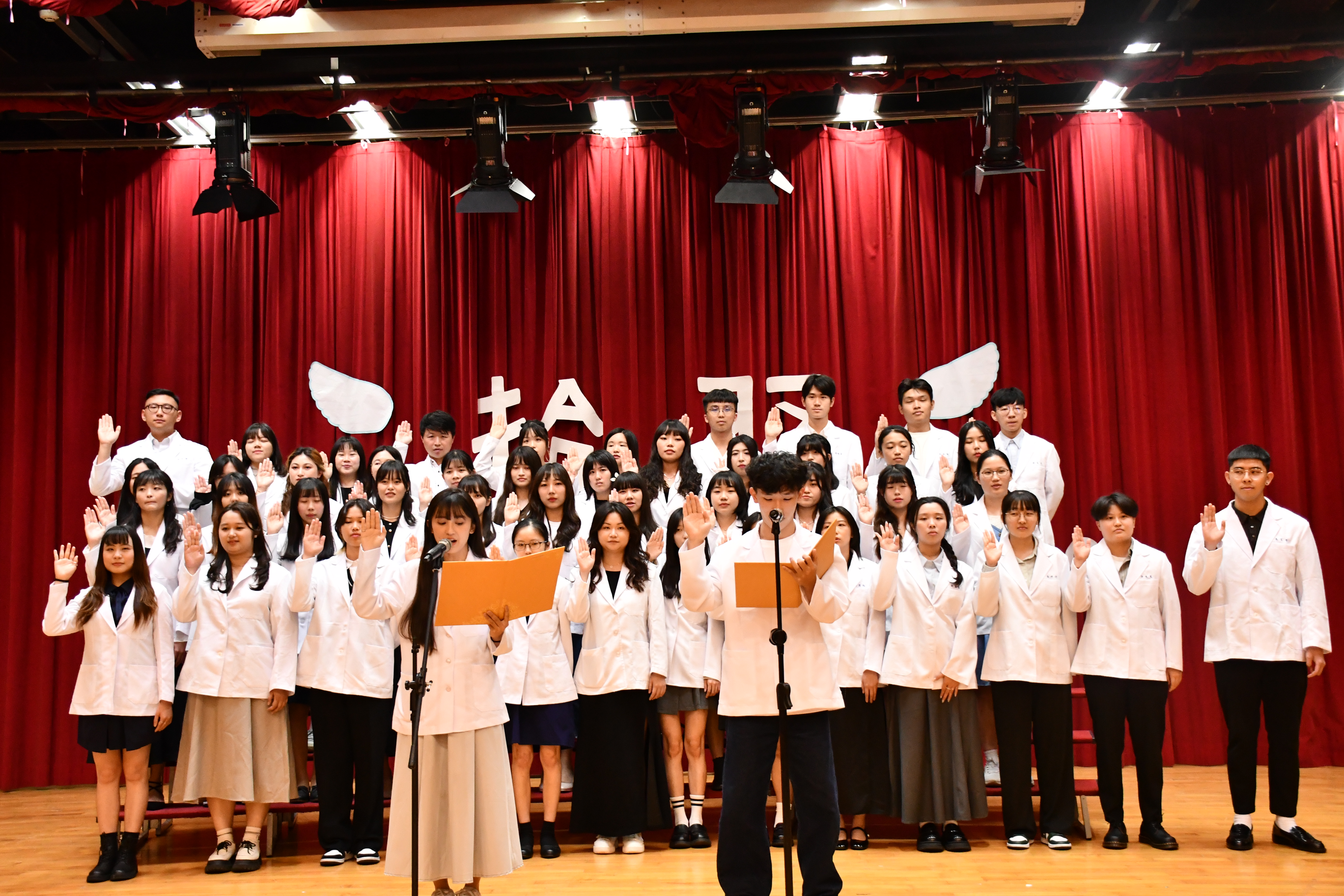 亞大聽語系同學穿上白袍後宣誓。